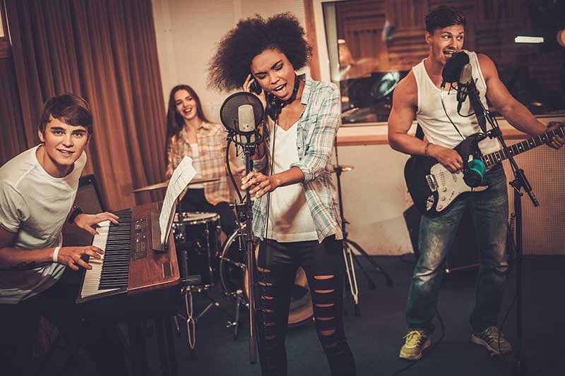Multiracial music band performing in a recording studio